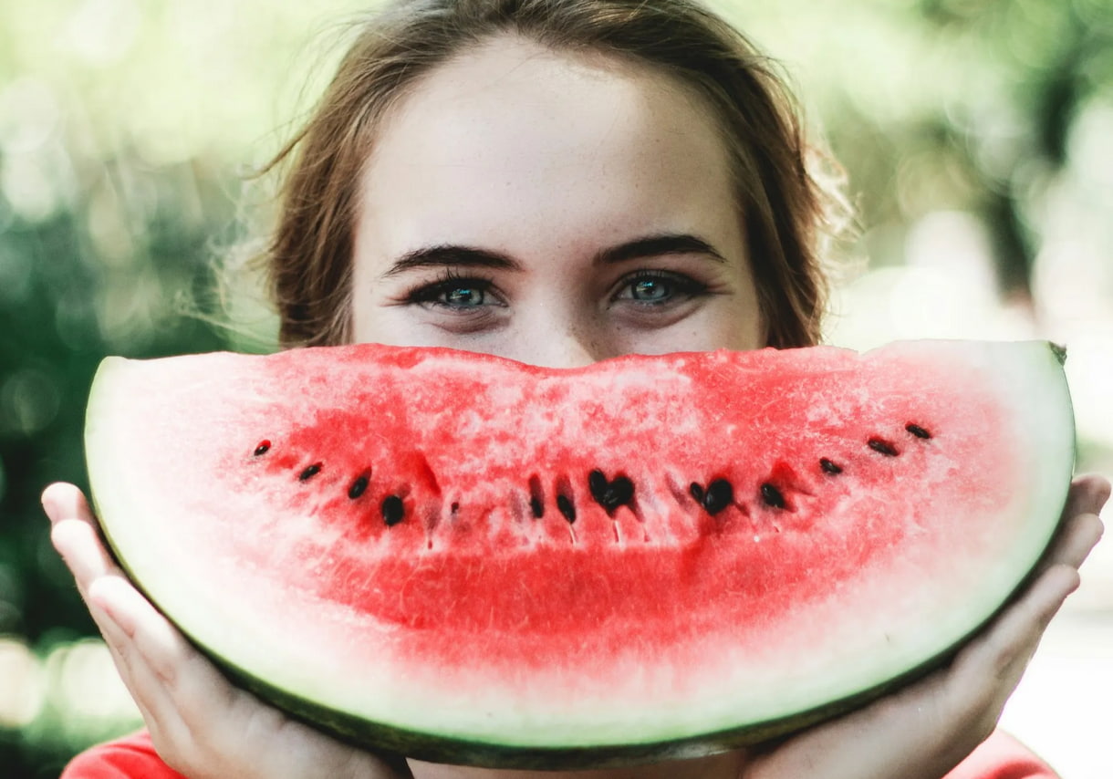 4 ways banks can achieve a good customer satisfaction score by using carbon emissions data - image of a happy customer holding a watermelon